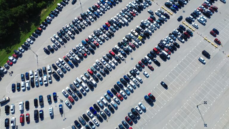 Aerial shot of parking lot full of rows of cars
