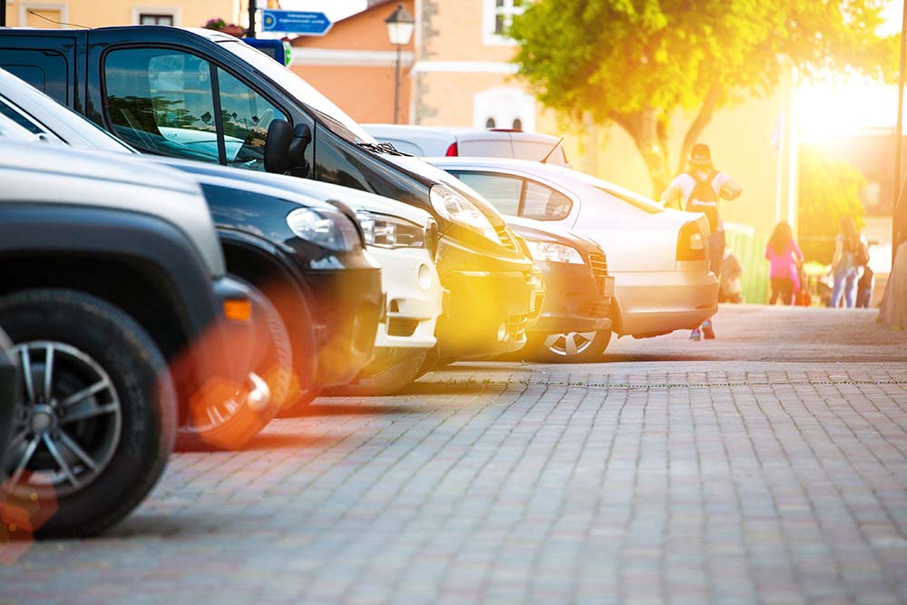 Parking of cars near the sidewalk for pedestrians, the cars stand in row on Campus Parking Management